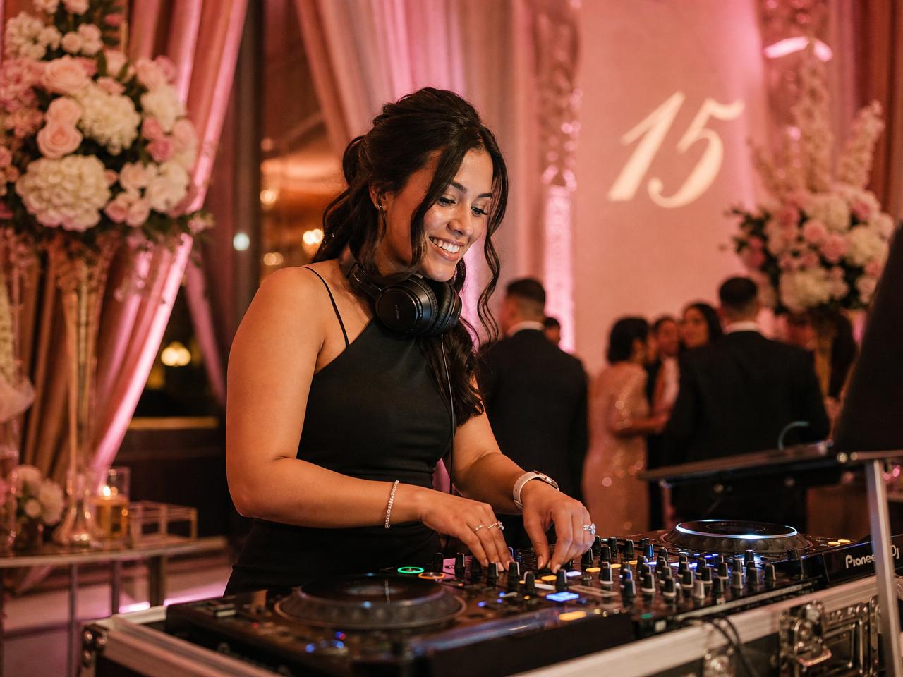 Woman DJ performing at a coming-of-age fifteenth birthday celebration with rose-gold lighting